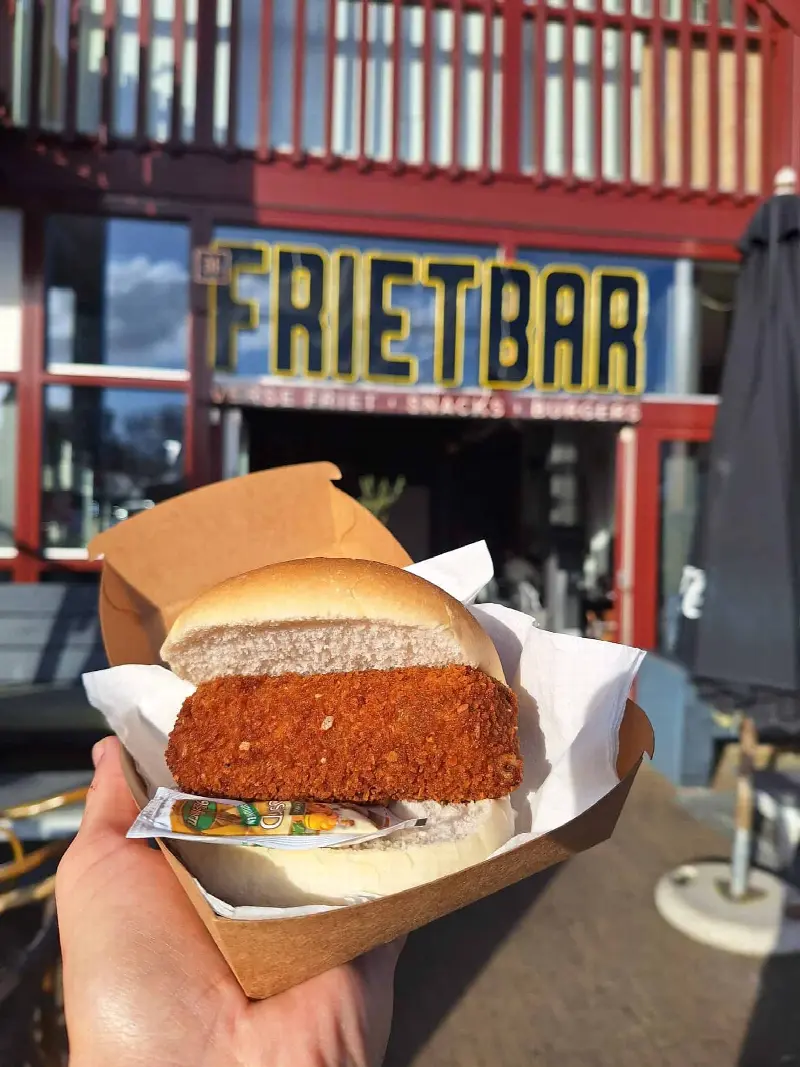 Broodje kroket met mosterd voor de gevel van De Frietbar